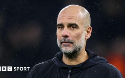 Pep Guardiola walks across the pitch