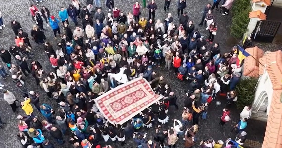 Junii Brașoveni sfidează gerul în Piața Unirii: Aruncatul în țol, spectacol tradițional